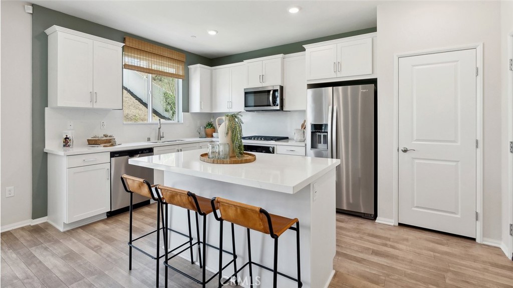 11392 Forge Road Corona, CA 92883 - Photo 7 of 24 a kitchen with stainless steel appliances a dining table and chairs