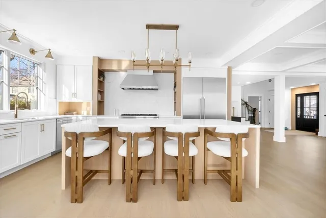 a dining hall with stainless steel appliances kitchen island granite countertop furniture and a view of kitchen