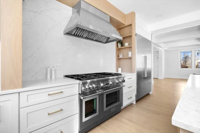a view of a kitchen with kitchen island a large window cabinets and stainless steel appliances