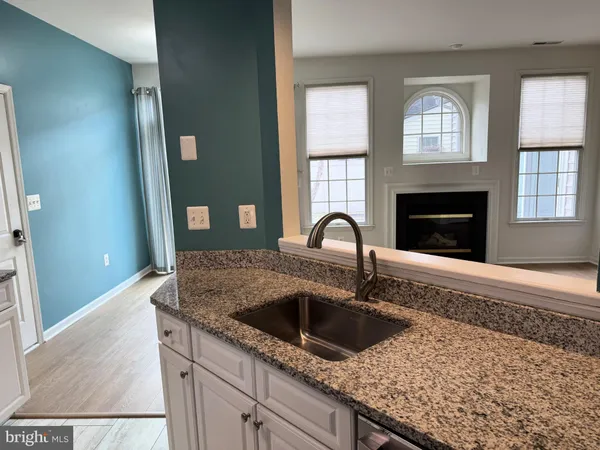 a kitchen with granite countertop a stove sink and cabinets