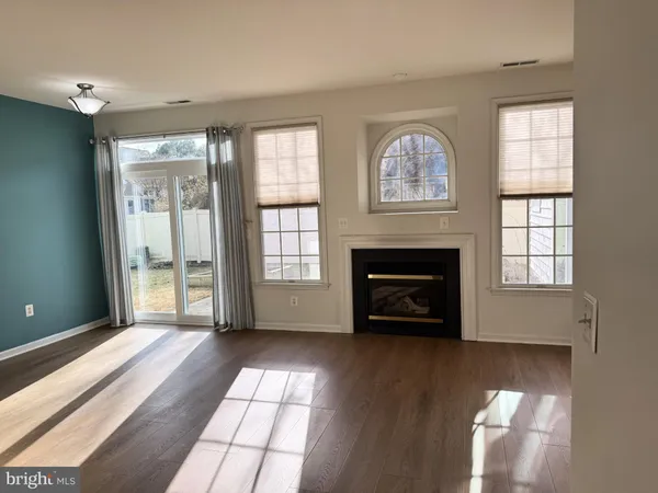 an empty room with windows and fireplace