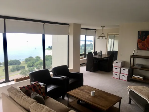 a living room with furniture and a floor to ceiling window
