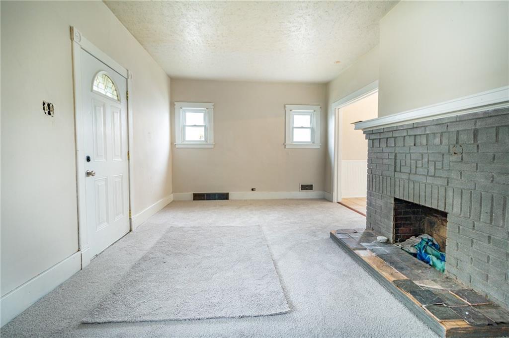 349 Orchard Street Springdale, PA 15144 - Photo 4 of 27 an empty room with windows and fireplace