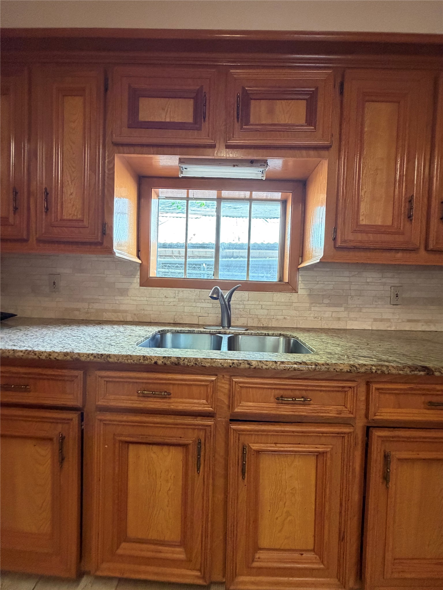 703 76th Street Houston, TX 77012 - Photo 10 of 23 a kitchen with granite countertop cabinets two sink and a window