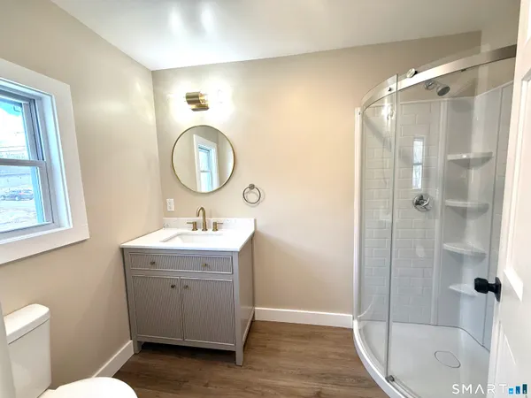 a bathroom with a sink a toilet and shower