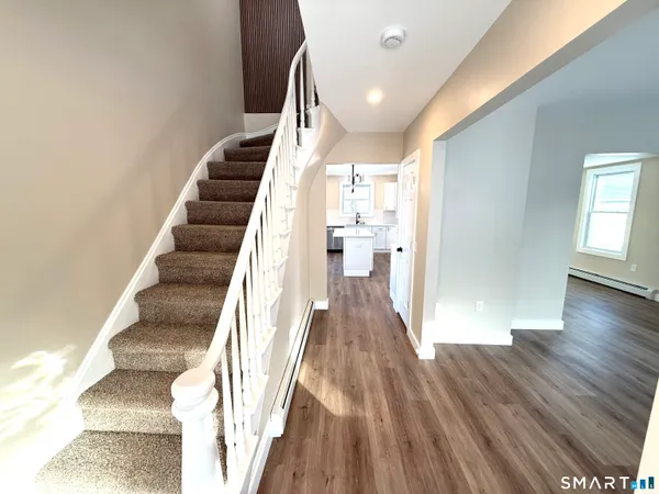 a view of a hallway with wooden floor and staircase