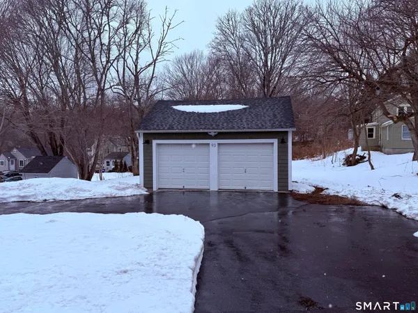 a front view of a house with a yard covered with snow