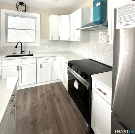 a kitchen with granite countertop a sink a stove and cabinets