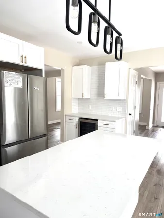 a kitchen with stainless steel appliances kitchen island a refrigerator sink and cabinets