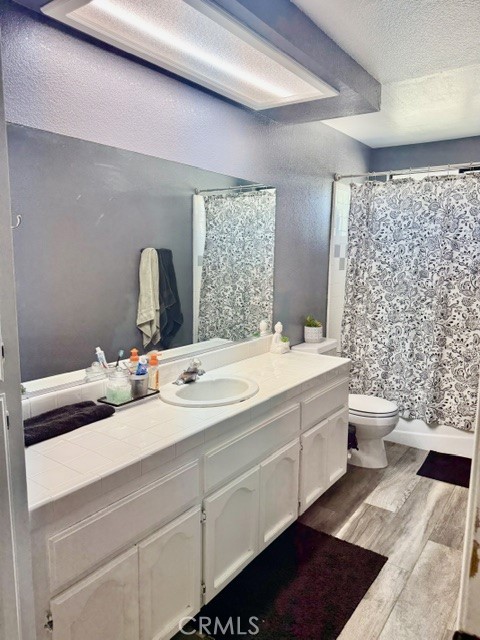 13375 Rincon Road Apple Valley, CA 92308 - Photo 32 of 72 a bathroom with a double vanity sink toilet and shower