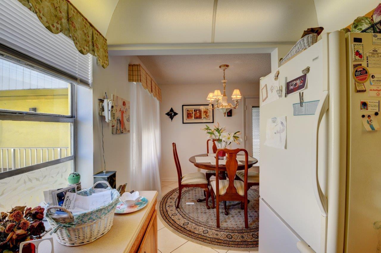 369 Capri H Delray Beach, FL 33484 - Photo 13 of 25 a view of a dining room with furniture and a chandelier