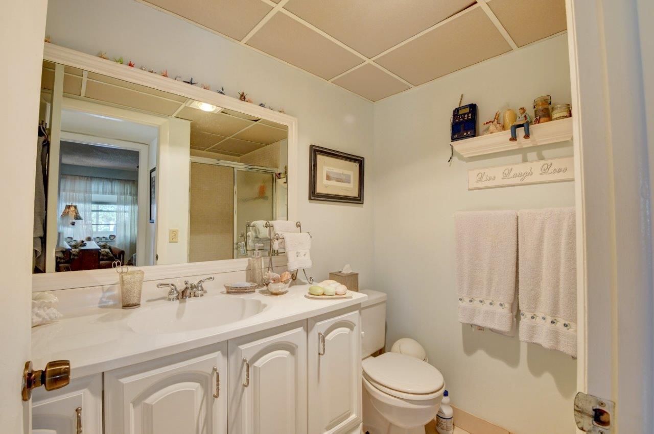 369 Capri H Delray Beach, FL 33484 - Photo 14 of 25 a bathroom with a sink a toilet and a mirror