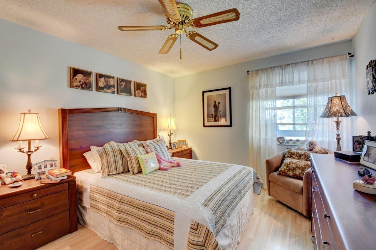 369 Capri H Delray Beach, FL 33484 - Photo 16 of 25 a bedroom with a bed and wooden floor