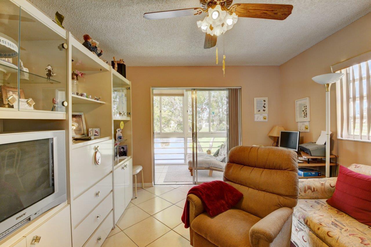 369 Capri H Delray Beach, FL 33484 - Photo 19 of 25 a spacious bedroom with furniture and a fireplace