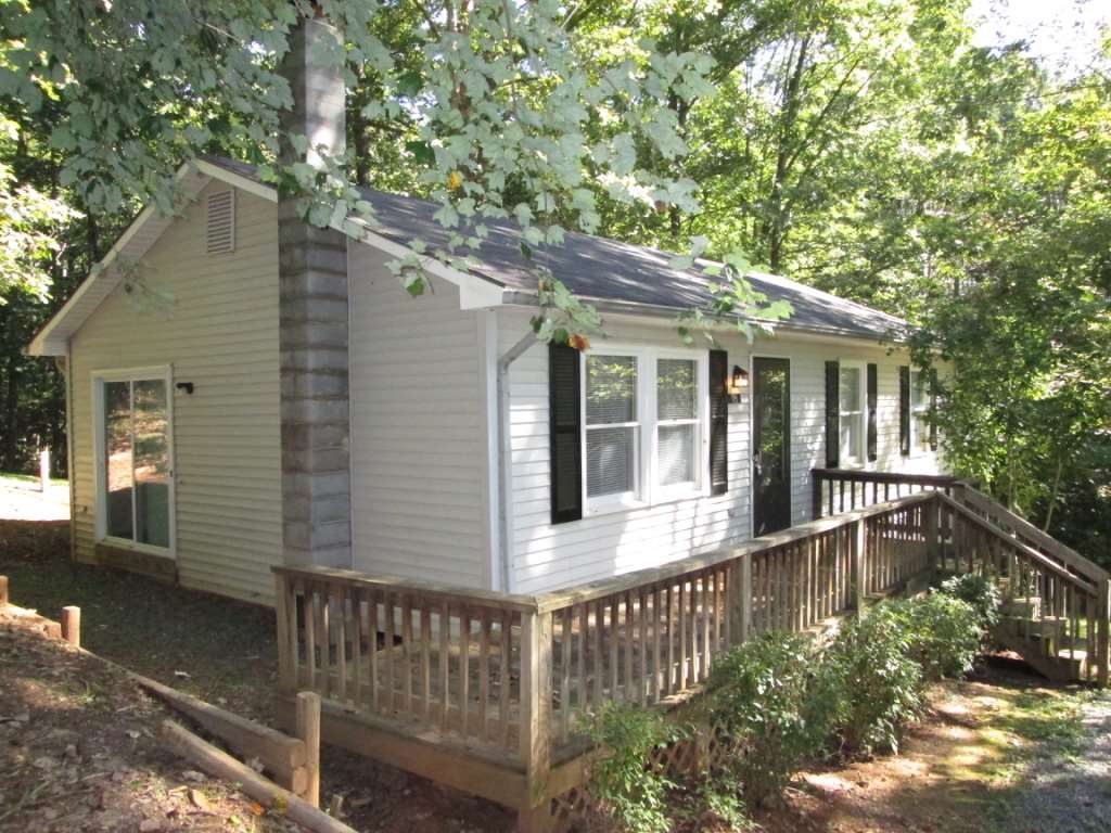 a view of a house with a small yard and wooden fence