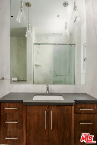 a bathroom with a granite countertop sink and a bathtub
