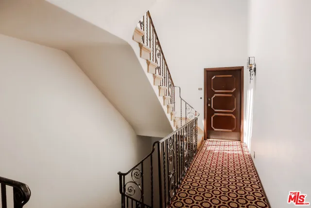 a view of a hallway with wooden floor and stairs