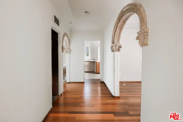 a view of a hallway with wooden floor and staircase
