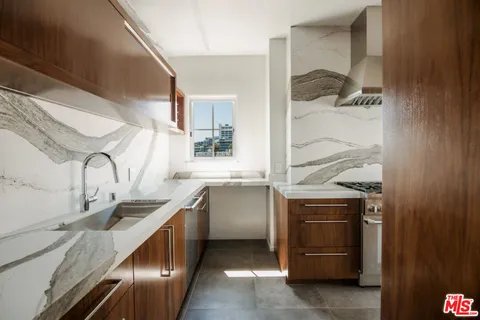 a kitchen with granite countertop a sink and a stove