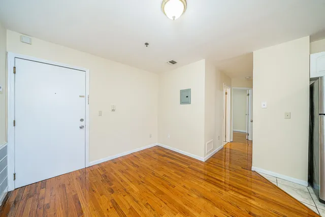 a view of empty room with wooden floor