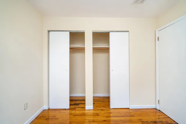 a view of empty room with wooden floor