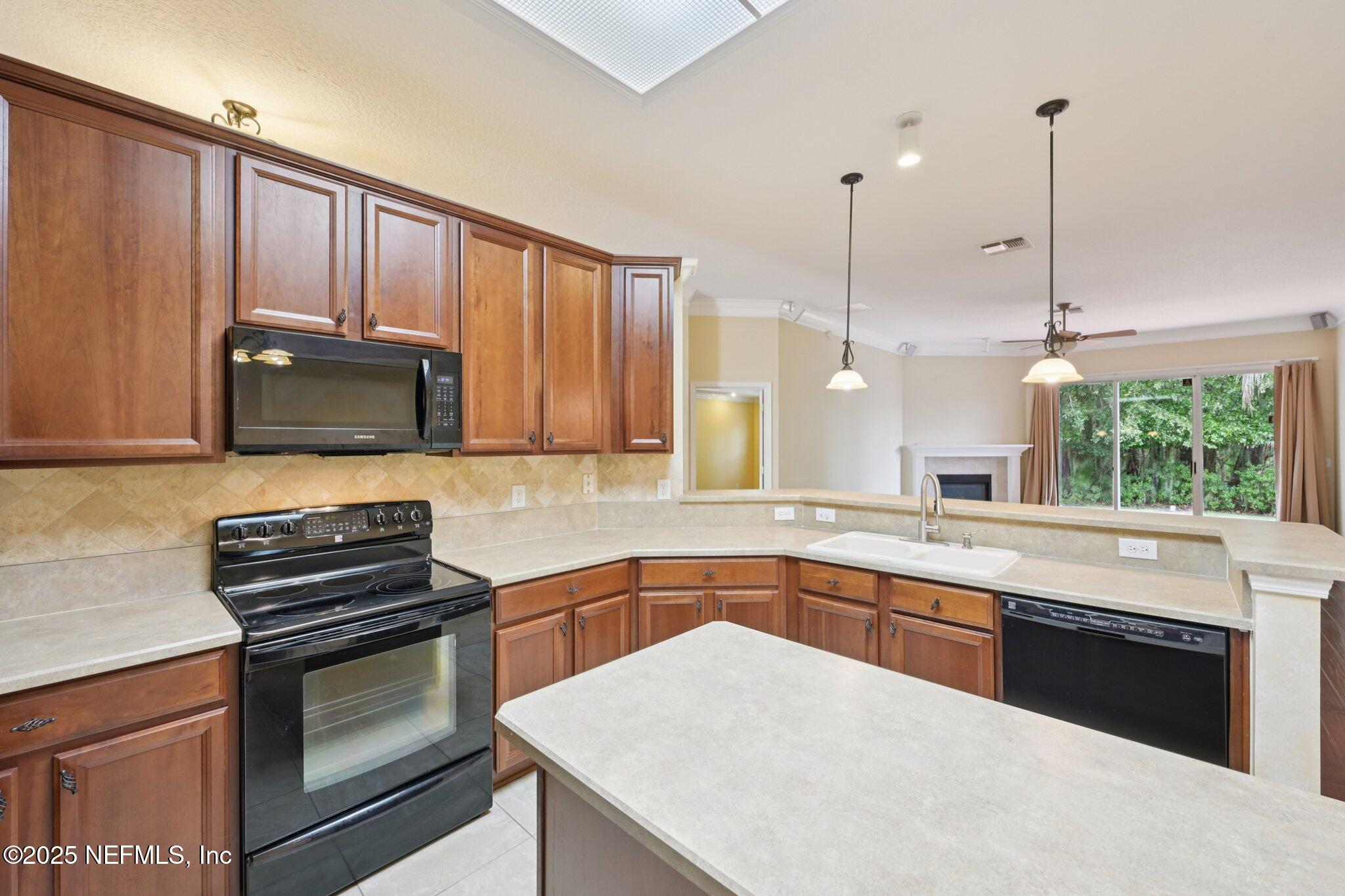 1734 Covington Lane Fleming Island, FL 32003 - Photo 18 of 54 a kitchen with a sink a stove and microwave