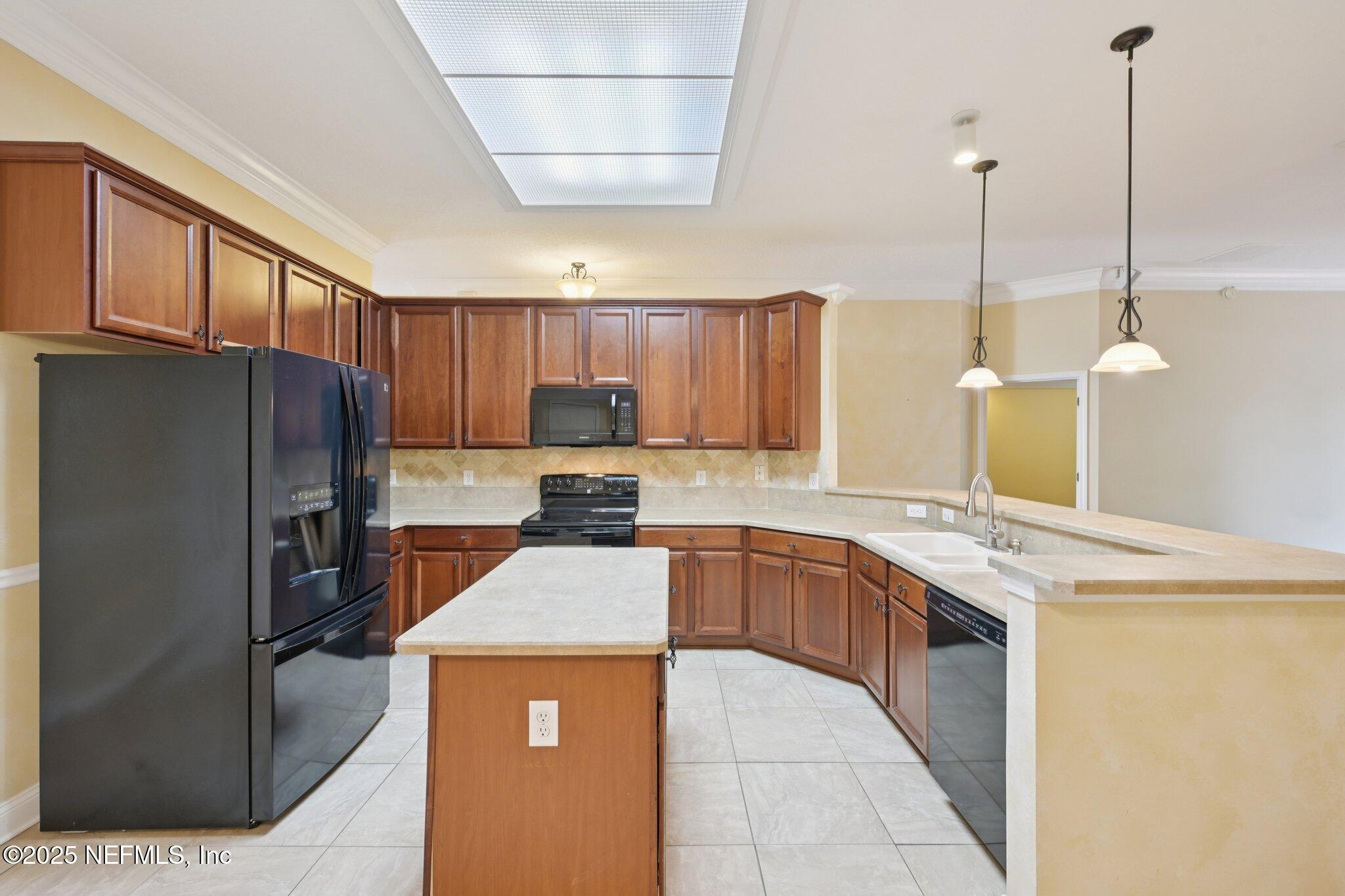 1734 Covington Lane Fleming Island, FL 32003 - Photo 19 of 54 a kitchen with stainless steel appliances granite countertop sink refrigerator and microwave