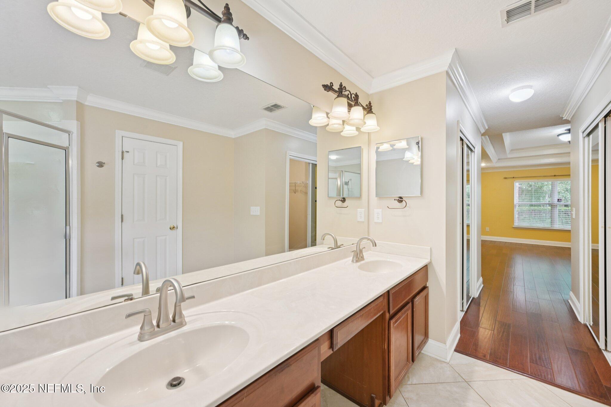 1734 Covington Lane Fleming Island, FL 32003 - Photo 28 of 54 a spacious bathroom with a double vanity sink mirror and chandelier