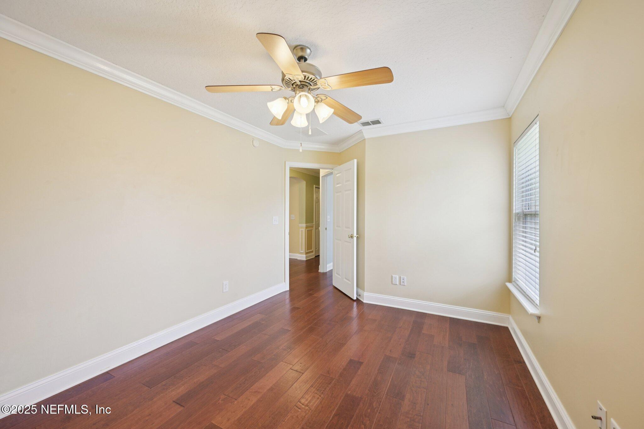 1734 Covington Lane Fleming Island, FL 32003 - Photo 30 of 54 an empty room with wooden floor fan and windows