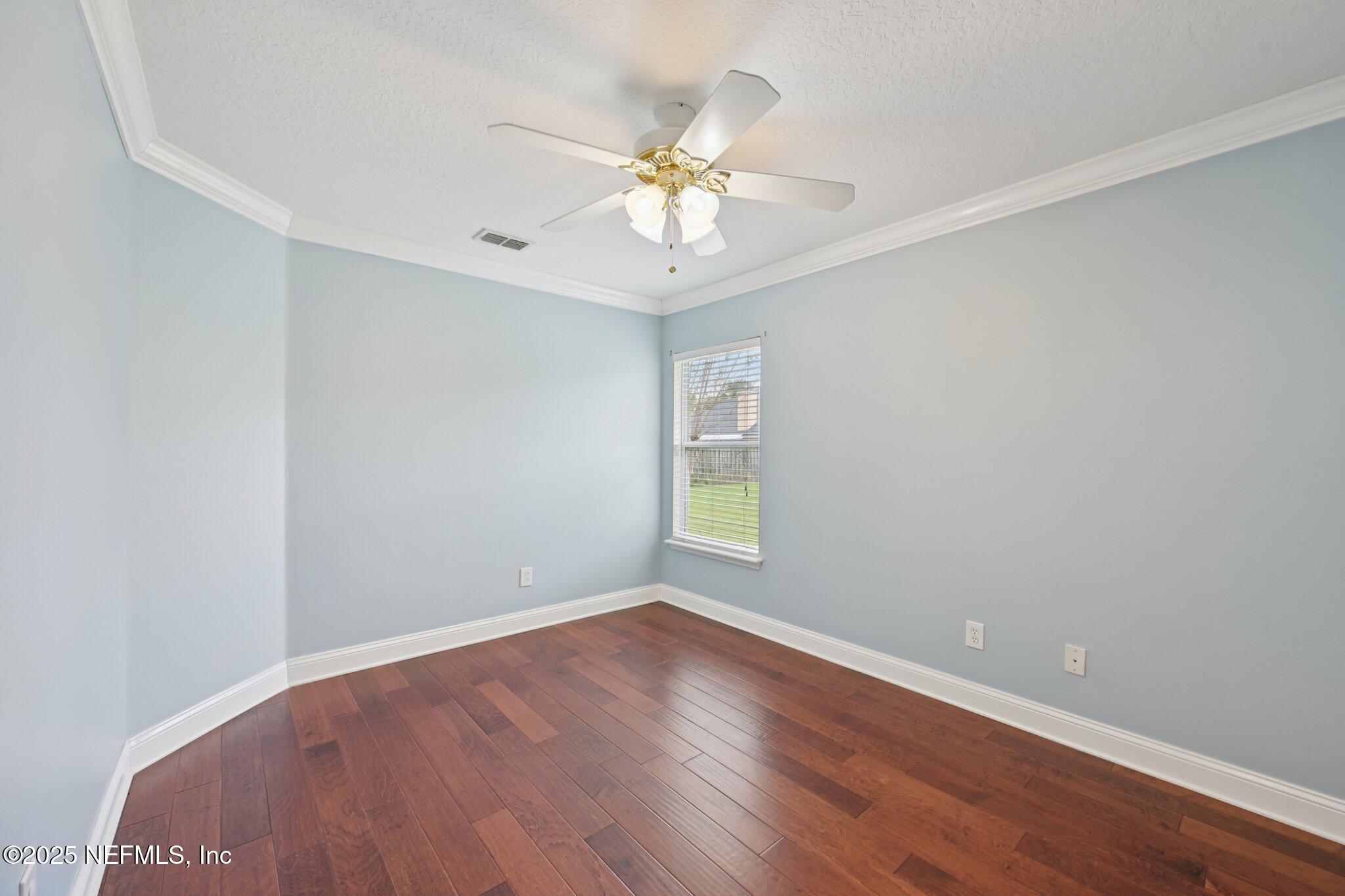 1734 Covington Lane Fleming Island, FL 32003 - Photo 31 of 54 an empty room with wooden floor fan and windows