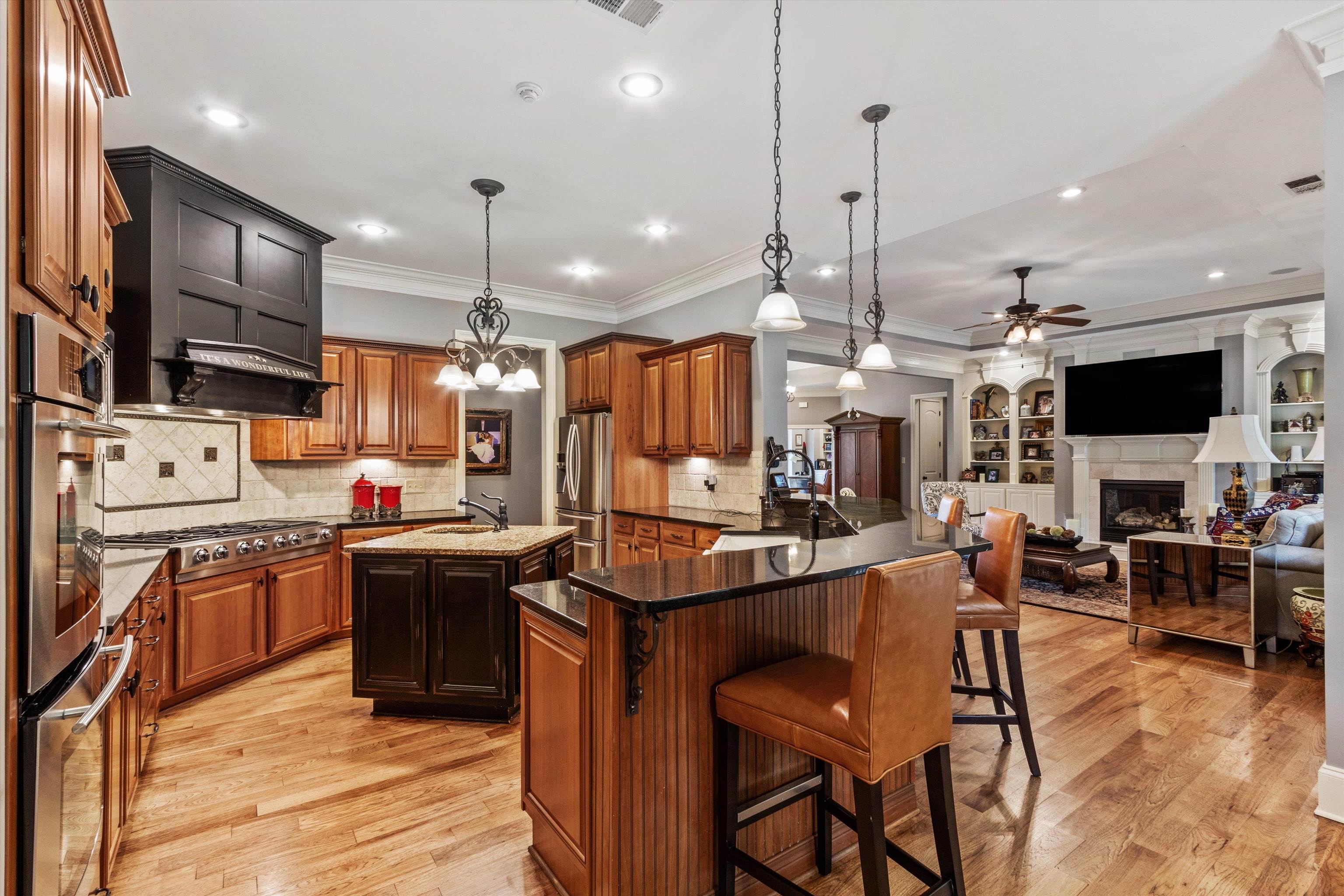 150 Ridgecrest Drive Arlington, TN 38002 - Photo 14 of 40 Gourmet kitchen featuring a stainless steel range with a custom wood hood, stone countertops, and wood-finish flooring
