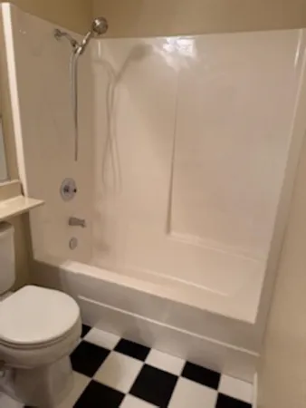 a bathroom with a toilet and a shower
