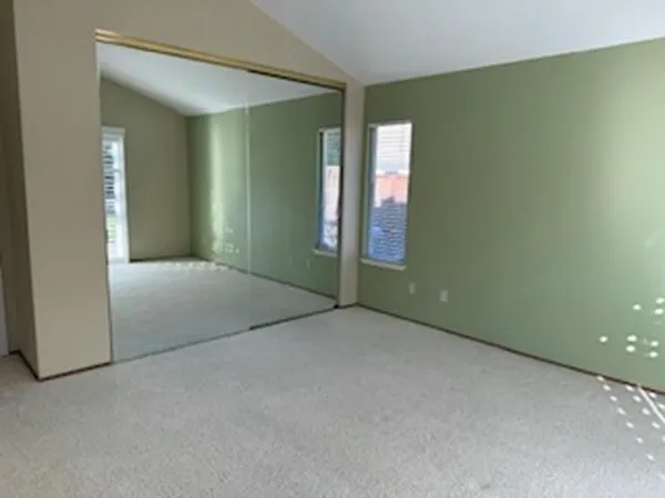 an empty room with closet and windows