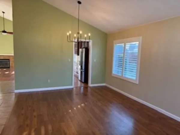 a view of a room with wooden floor chandelier and window