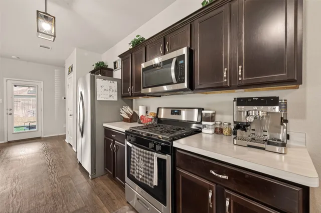 a kitchen with stainless steel appliances a stove a sink and a microwave