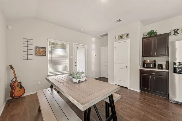 a kitchen with a table chairs and refrigerator