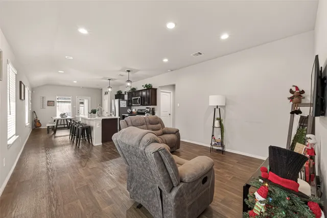 a living room with furniture and a wooden floor