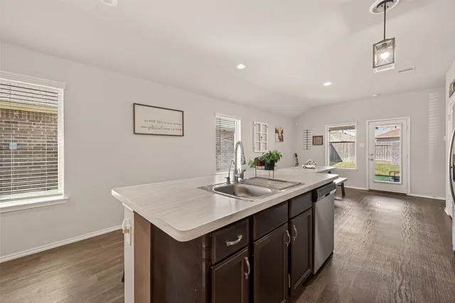 a kitchen with a sink cabinets and wooden floor