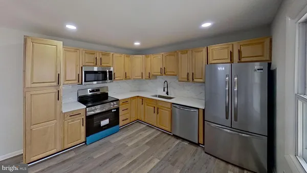 a kitchen with a refrigerator cabinets stainless steel appliances and a window