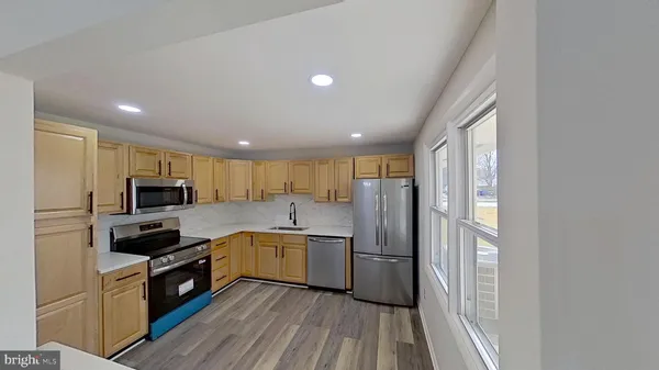 a kitchen with stainless steel appliances granite countertop a refrigerator a stove top oven a sink and dishwasher