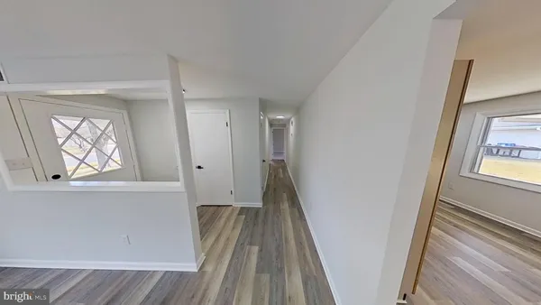 a view of hallway with a large window and wooden floor