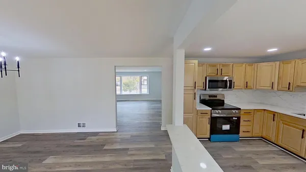 a large kitchen with cabinets wooden floor and stainless steel appliances