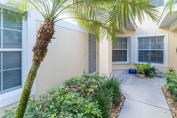 a front view of a house with a yard and potted plants