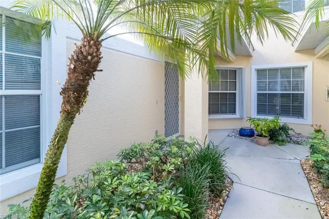a front view of a house with a yard and potted plants