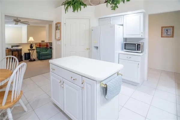 a kitchen with a refrigerator and white cabinets