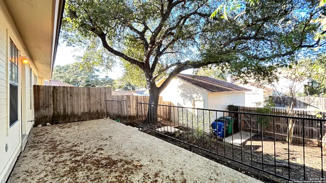 a view of a house with a small yard and wooden fence