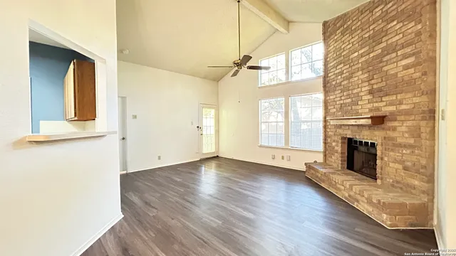 a view of a livingroom with wooden floor and a fireplace
