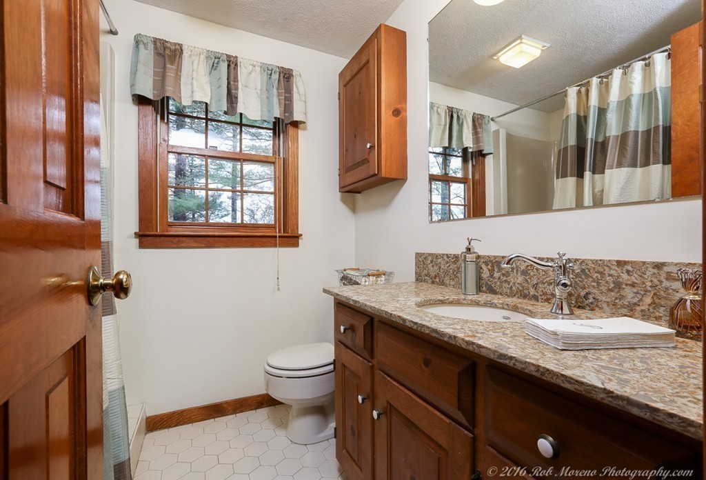 68 B Rowley Road Boxford, MA 01921 - Photo 15 of 30 a bathroom with a granite countertop sink a toilet and a mirror