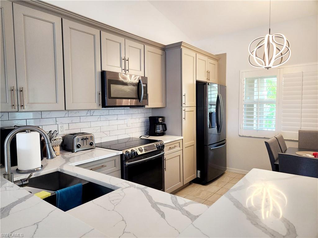 a kitchen with stainless steel appliances a stove refrigerator sink and cabinets