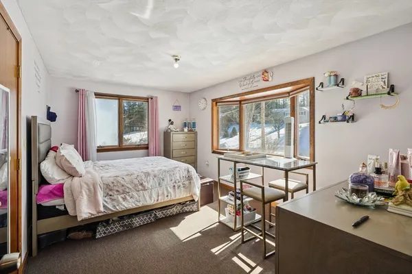 a bedroom with a bed and large windows
